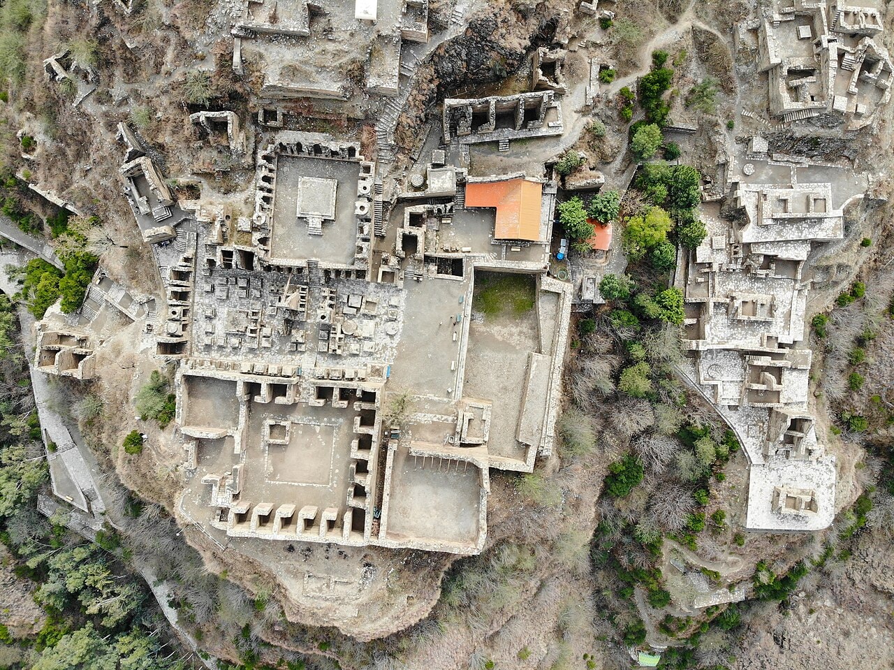 An aerial view of the ruins of the Takht-i-Bahi Buddhist monastery on a hilltop.