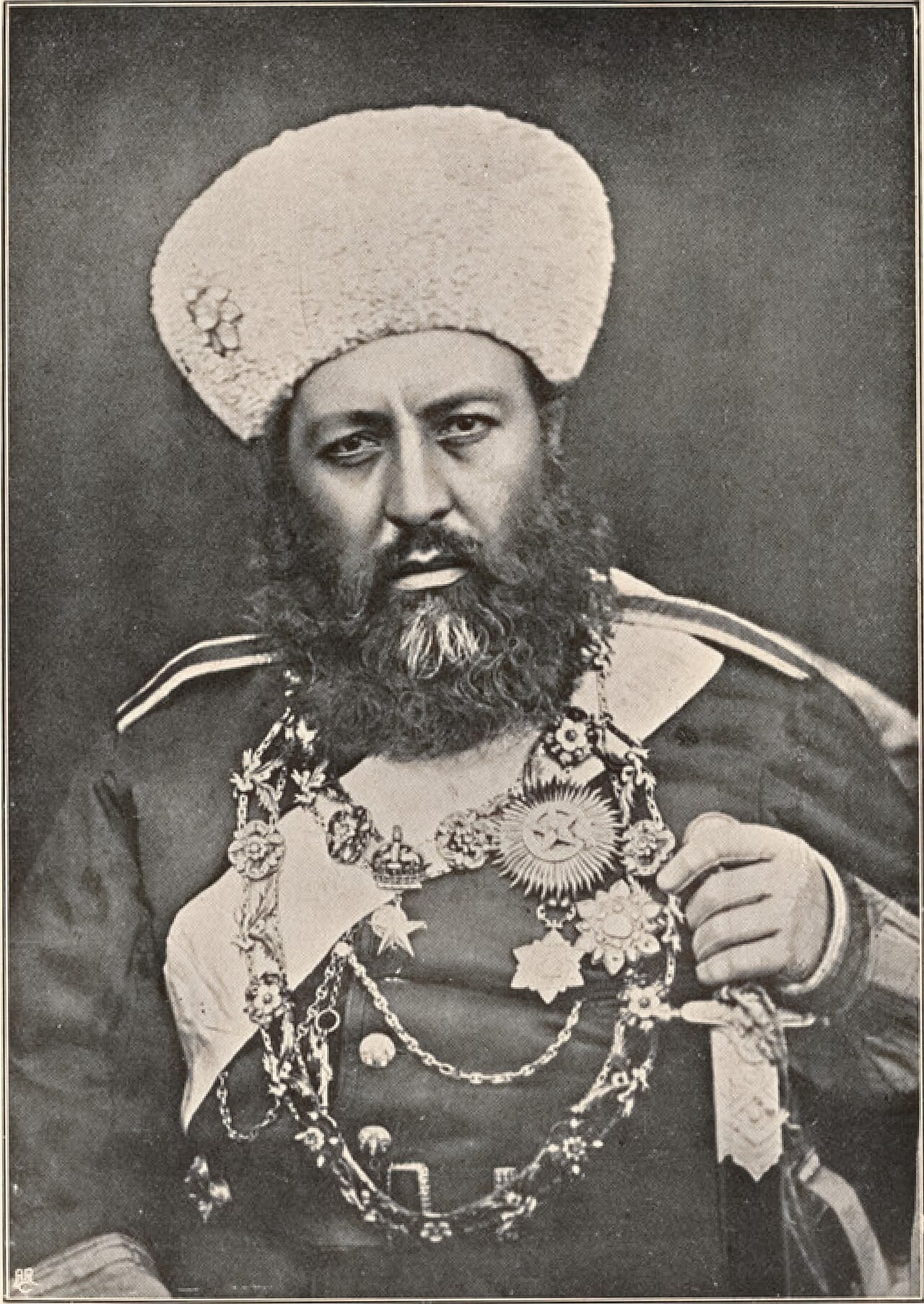 A formal portrait photograph of Amir Abdur Rahman Khan seated in uniform and turban.