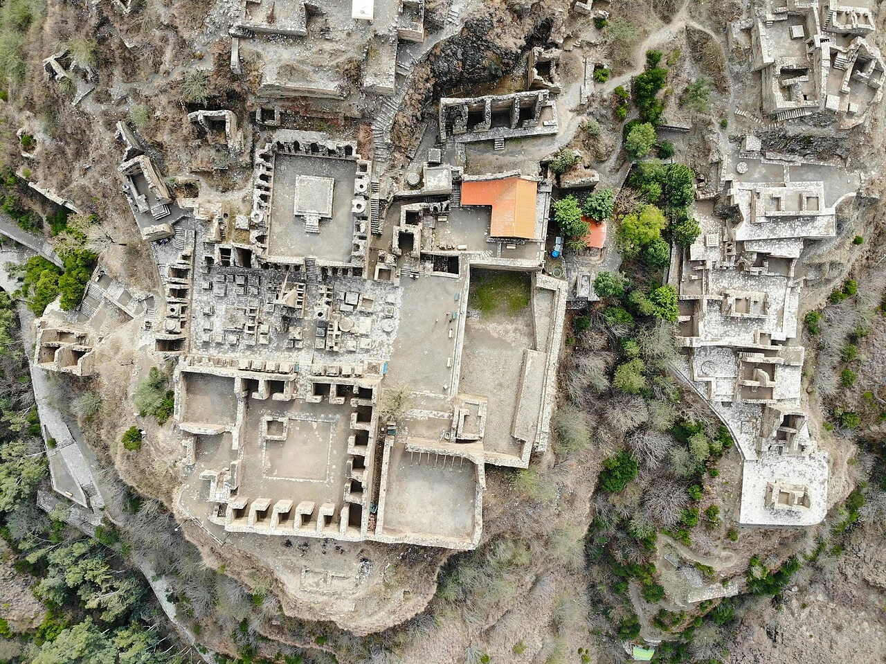 An aerial view of the ruins of the Takht-i-Bahi Buddhist monastery on a hilltop.
