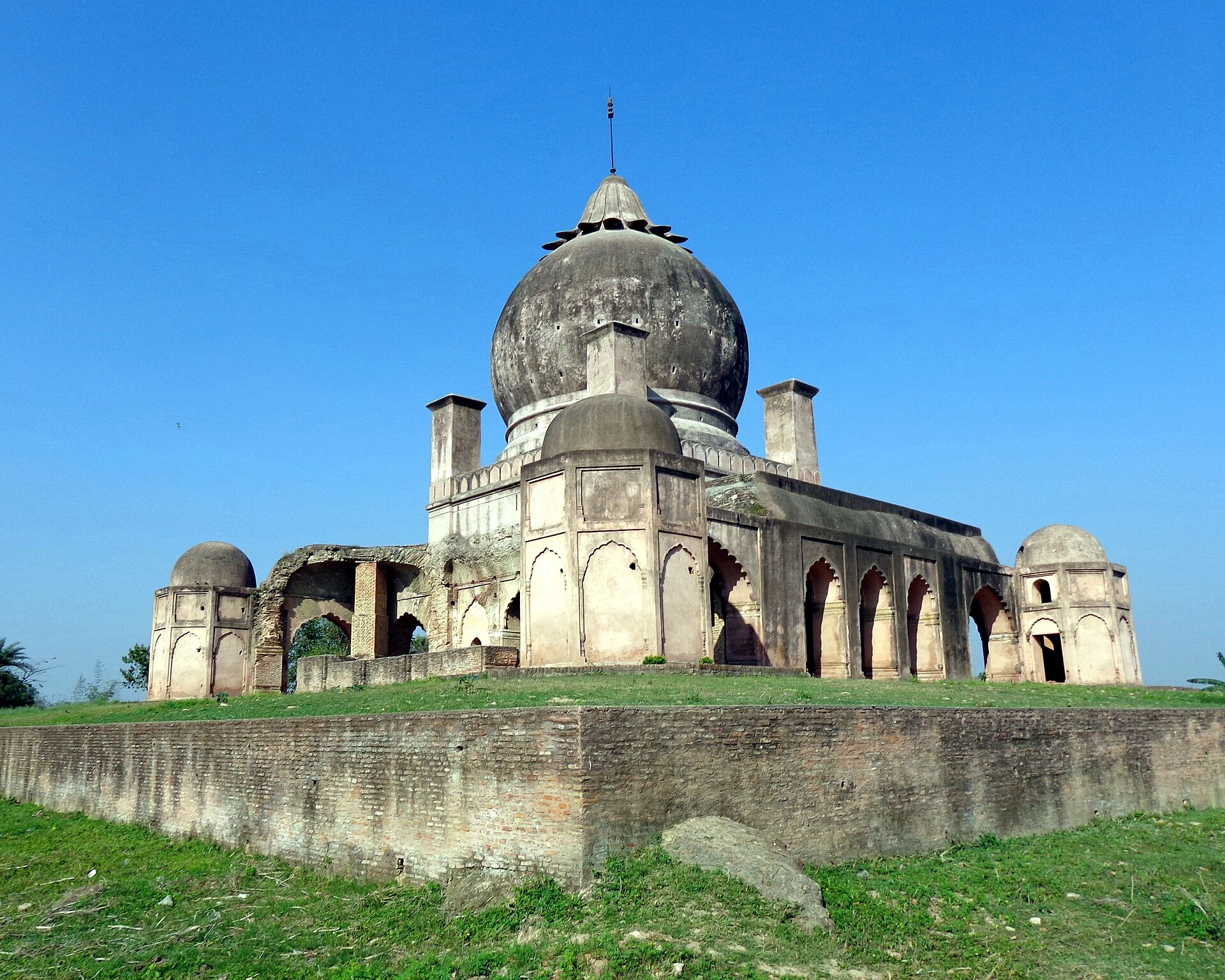 A domed brick and plaster tomb on a raised platform