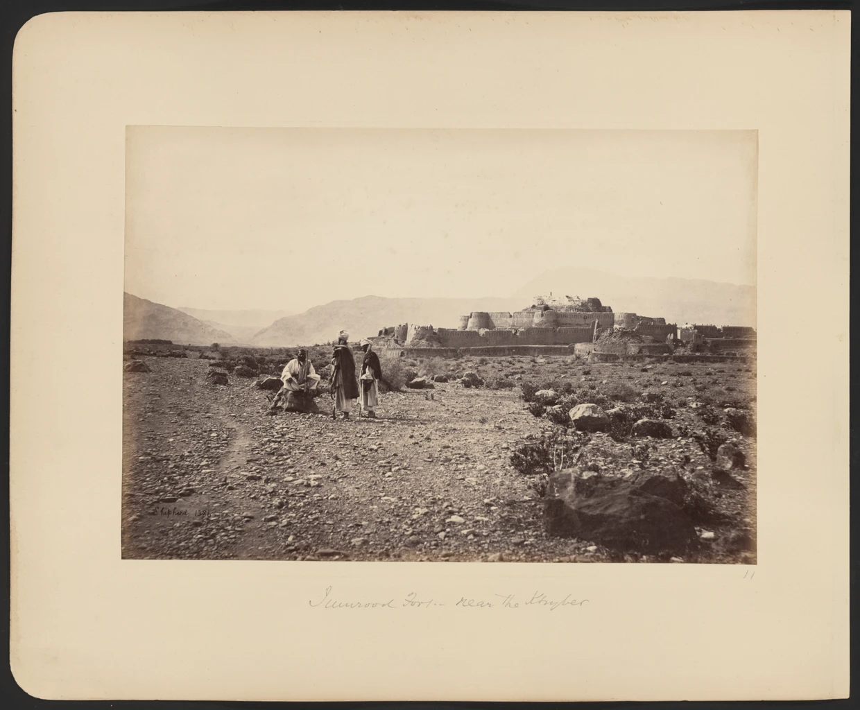 Jamrud fort on a rise, with three armed men in the foreground