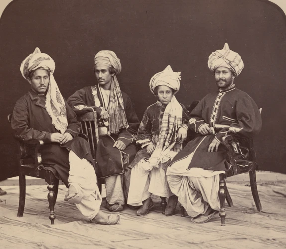 Old photograph of four young men in embroidered clothes and turbans