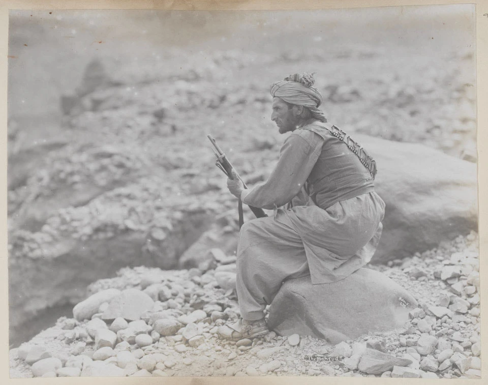 Photograph of a man in a turban holding a rifle