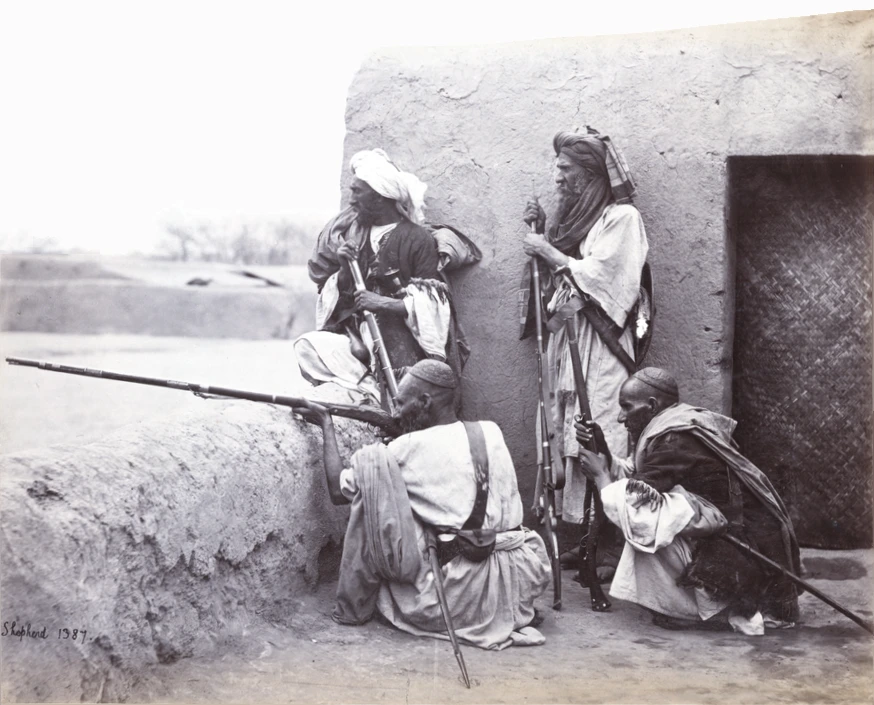 A group of Afridi men standing and sitting with rifles at Jamrud.
