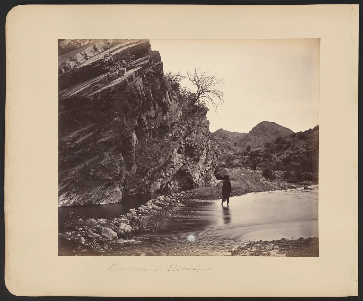A black-and-white photograph of the fort and shrine of Ali Masjid seen from the pass below.